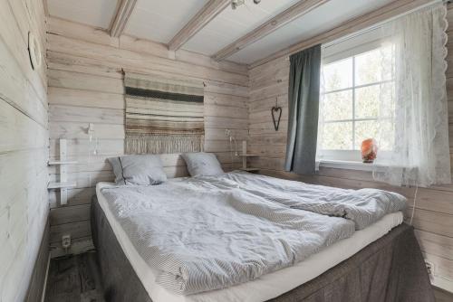 1 cama blanca grande en una habitación con ventana en Seaside holiday home in Axmar north of Gavle, en Bergby