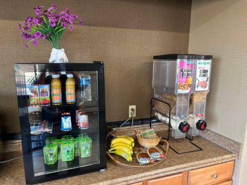 a kitchen counter with a refrigerator and some drinks at SureStay by Best Western Glendive Yellowstone River in Glendive