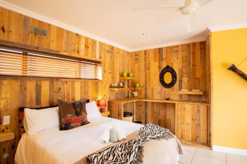 sypialnia z drewnianymi ścianami i dużym łóżkiem w obiekcie bWhale guest house w mieście Knysna