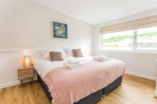 a bedroom with a bed and a window at Cairn Dyke Lodge in Gatehouse of Fleet