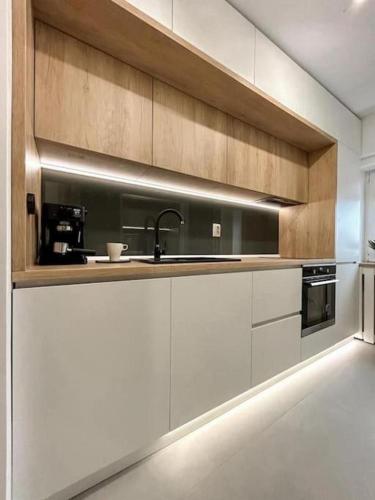 a kitchen with white cabinets and a sink at Genesis - Iasi City Center in Iaşi