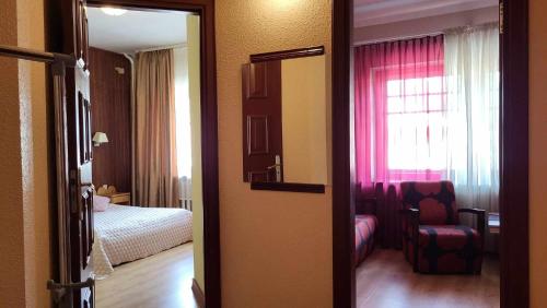 a room with a bedroom with a bed and a mirror at Ierullē in Alūksne