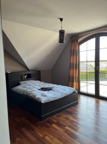 a bedroom with a bed and a large window at LakeHouse in Giewartów