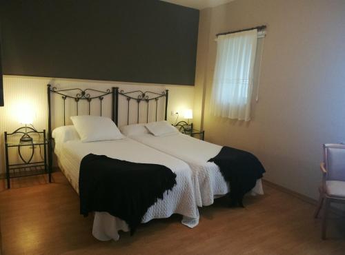a bedroom with a large bed with black and white sheets at Hotel La Farola del Mar in poo de Llanes