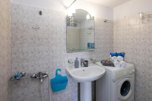 a bathroom with a sink and a washing machine at Tinos 2 bedrooms 5 persons apartment by MPS in Khatzirádhos