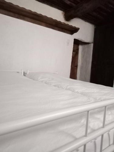 a white bed sitting in a room with a wall at Koca Kapı Konaklama in Yeşilova