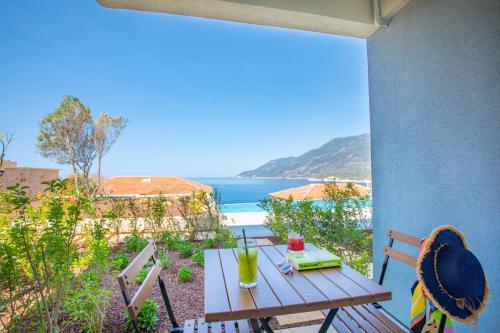 a table and chairs on a balcony with a view of the ocean at Mavilim Hotel in Kas