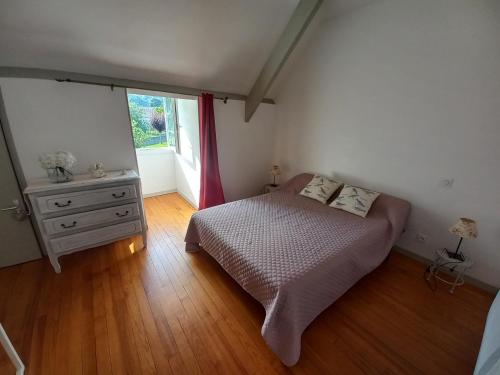 een slaapkamer met een bed, een dressoir en een raam bij Maison de vacances in Adé