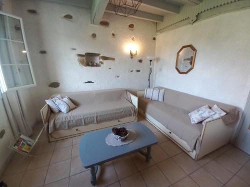 uma sala de estar com um sofá e uma mesa em Maison de vacances em Adé