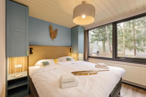 1 dormitorio con cama grande y ventana grande en Center Parcs Huttenheugte Drenthe-Overijssel, en Dalen