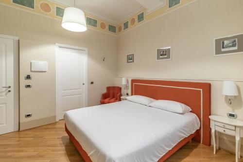 a bedroom with a bed and a table and a door at Casa Isolani Luxury Rooms Piazza Maggiore 1 in Bologna