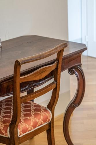 a wooden table and a chair with a wooden table at Casa Isolani Luxury Rooms Piazza Maggiore 1 in Bologna