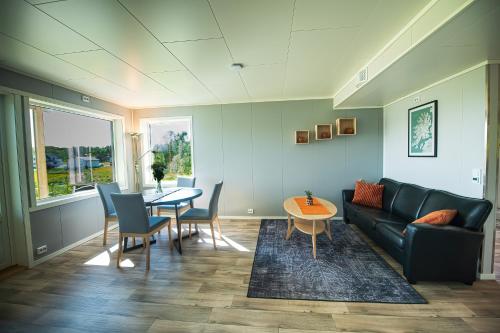 a living room with a couch and a table at Senja Fjordhotell and Apartments in Stonglandseidet
