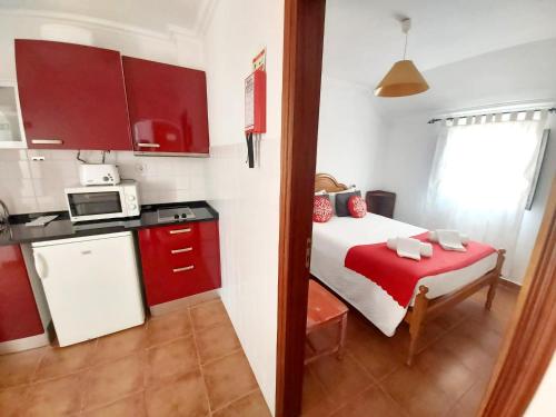 a small kitchen with a small bed in a room at Mateus Studios & Apartments - Duna Parque Group in Vila Nova de Milfontes