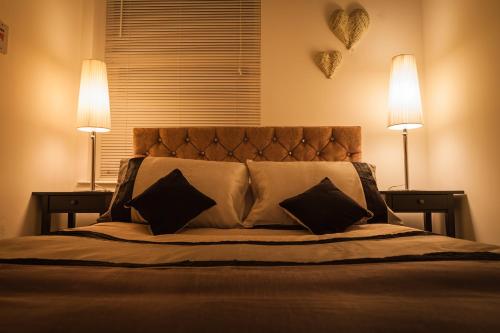 Urban Chic Suite - Simple2let Serviced Apartments في هاليفاكس: غرفة نوم بها سرير مع مصباحين