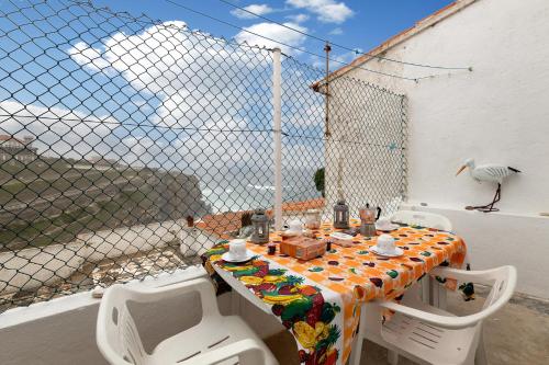 una mesa y sillas en un balcón con un pájaro en Casa Sol e Mar, en Colares