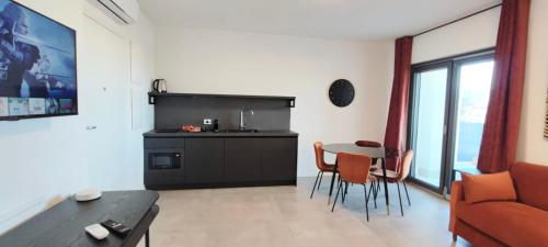 uma sala de estar com uma cozinha e uma mesa e cadeiras em Marisabella Suite Spa 5 em Bari
