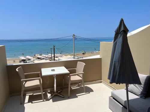a balcony with a table and chairs and the beach at Agios Gordios Beach Resort in Agios Gordios