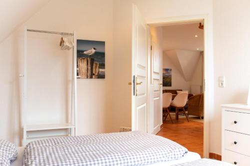 um quarto com uma cama e uma sala de jantar em Ferienhaus Canvas Canvas Carolinensiel FeWo "Wangerooge" em Wittmund