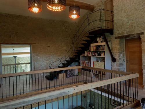 a spiral staircase in a room with a book shelf at Bordeneuve Chalet de Gaïa in Sonnac-sur-lʼHers