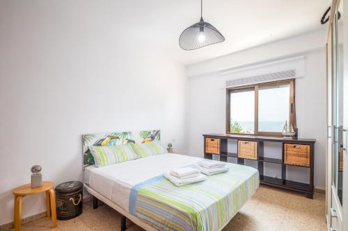 バレンシアにあるIsola Beachside Apartmentのベッドと窓のある寝室