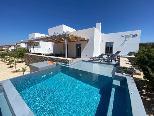 eine Villa mit einem Pool vor einem Haus in der Unterkunft Bluebell Resort Villa SUNRISE in Kampos Paros