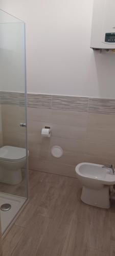 La salle de bains est pourvue de toilettes et d'une douche en verre. dans l'établissement Casa Mirella, à Sanremo