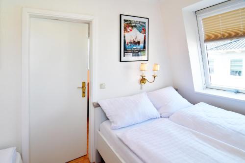 a white bedroom with a bed and a window at Hamburg-App-08 in Ahlbeck
