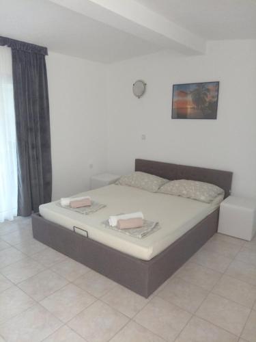 a bedroom with a bed with two towels on it at Apartments Šešo in Pag