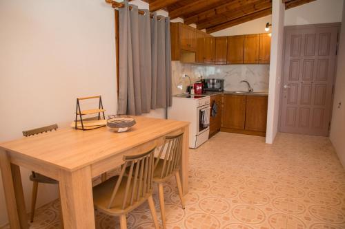 a kitchen with a wooden table and some chairs at Blue Sea View Prime Apartment, Porto Heli in Porto Heli