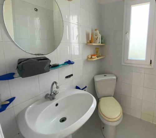uma casa de banho com um lavatório, um WC e um espelho. em Belle maison en face de la mer em El Maamoura