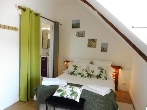 - une chambre avec un lit doté d'oreillers verts et blancs dans l'établissement Gîtes du Guébriand, à Saint-Lormel