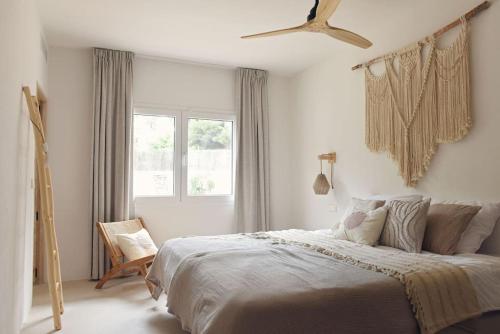 a white bedroom with a large bed and a window at Casa dos Islas in San Antonio Bay