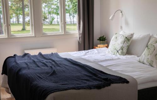 een bed met een zwarte deken in een kamer met ramen bij Visby Gustavsvik in Visby