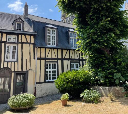 een oud zwart-wit huis met een boom bij Appartement au cœur du vieux Rouen in Rouen