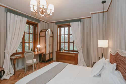 una camera con letto, scrivania e finestre di Il Paese Boutique Hotel 