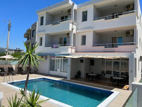 a villa with a swimming pool in front of a building at Apartments Fat e Jet in Ulcinj