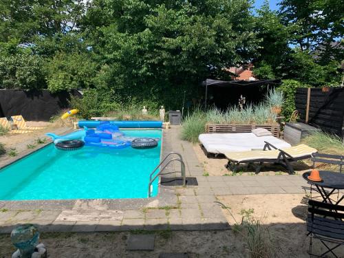 una piscina con una mesa y una cama en un patio en Farm61 badehotellet i det midtjydske - alder +18 år, en Tjele