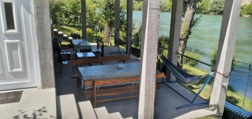 a balcony with a table and chairs and a view of the water at Prenoćište na Drini Foča in Foča