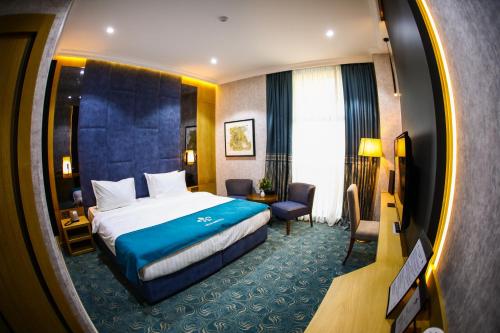 Pokój hotelowy z łóżkiem, biurkiem i krzesłem w obiekcie Iris Hotel Baku - Halal Hotel w mieście Baku