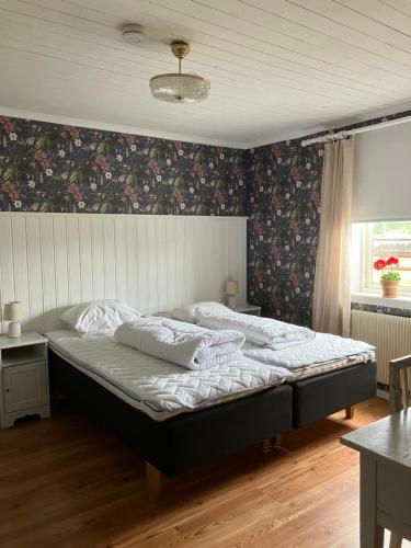 a bedroom with a large bed with floral wallpaper at Karaby Gård, Country Living in Kristinehamn