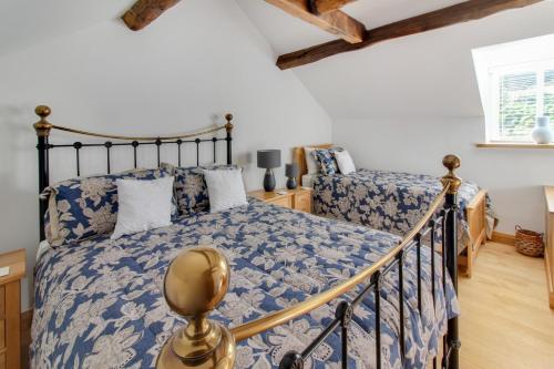 a bedroom with a bed with a blue and white comforter at The Mill Nant Alyn in Rhydymwyn