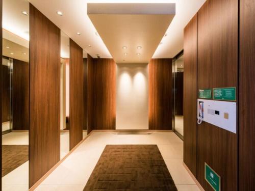 a hallway with wood paneling and a hallway with a rug at Super Hotel Tokyo Kinshicho Ekimae / Vacation STAY 79346 in Tokyo