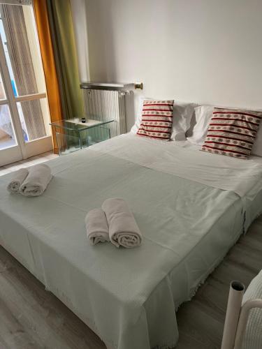 uma grande cama branca com toalhas em cima em Appartamento Bilocale Moderno Marina Centro Rimini em Rimini
