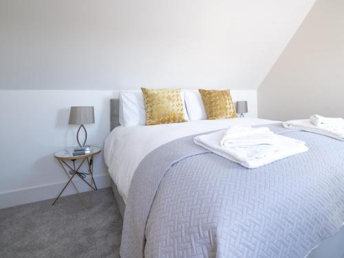 a white bedroom with a bed and a table at Pass the Keys Chestnut Cottage parking stunning views in Chipping Campden