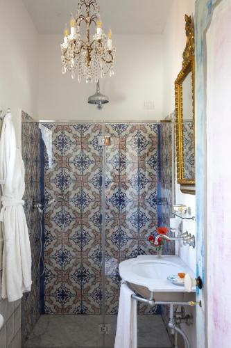 a bathroom with a sink and a chandelier at Villa De Cillis Carafa in Torre del Greco