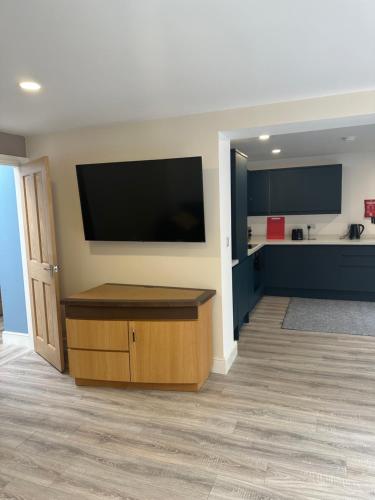 a living room with a flat screen tv on a wall at Newland Park Bungalow Near Hull Uni Free Parking Free Wi-Fi in Hull
