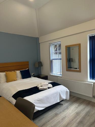 a bedroom with a large bed and a mirror at Newland Park Bungalow Near Hull Uni Free Parking Free Wi-Fi in Hull
