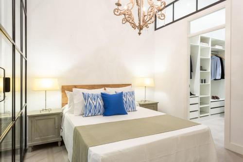 a bedroom with a bed with blue pillows and a chandelier at Acogedor apt en Chamberí in Madrid