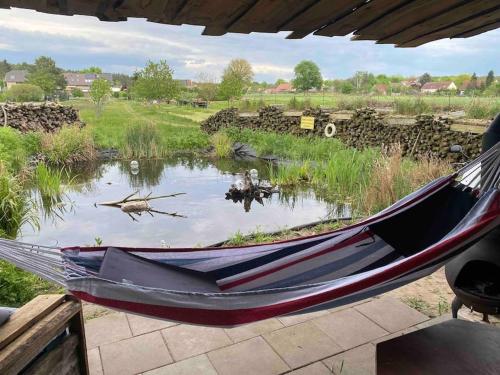 a hammock in front of a pond in a field at Auszeit inmitten der Natur - its a kind of magic in Freienthal